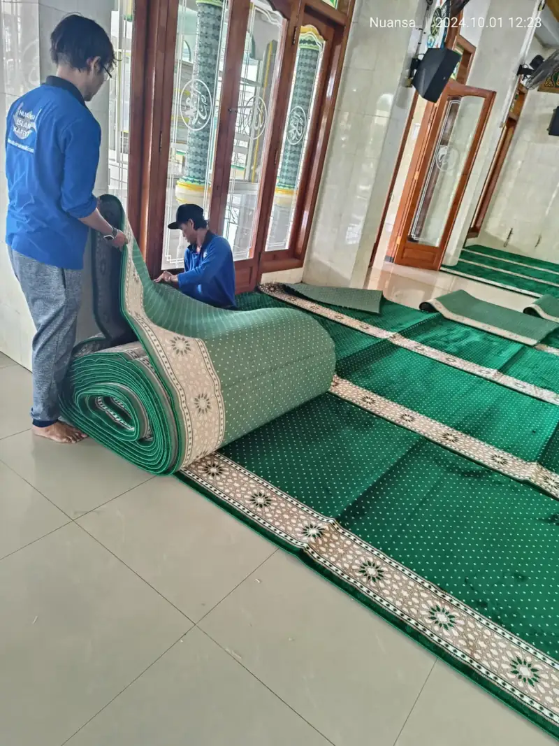 Tim Nuansa menggelar roll karpet di dalam masjid
